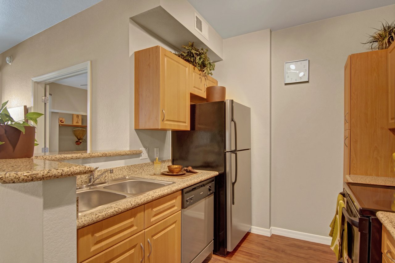 Kitchen with stainless steel appliances, granite countertops, and wood cabinets.
