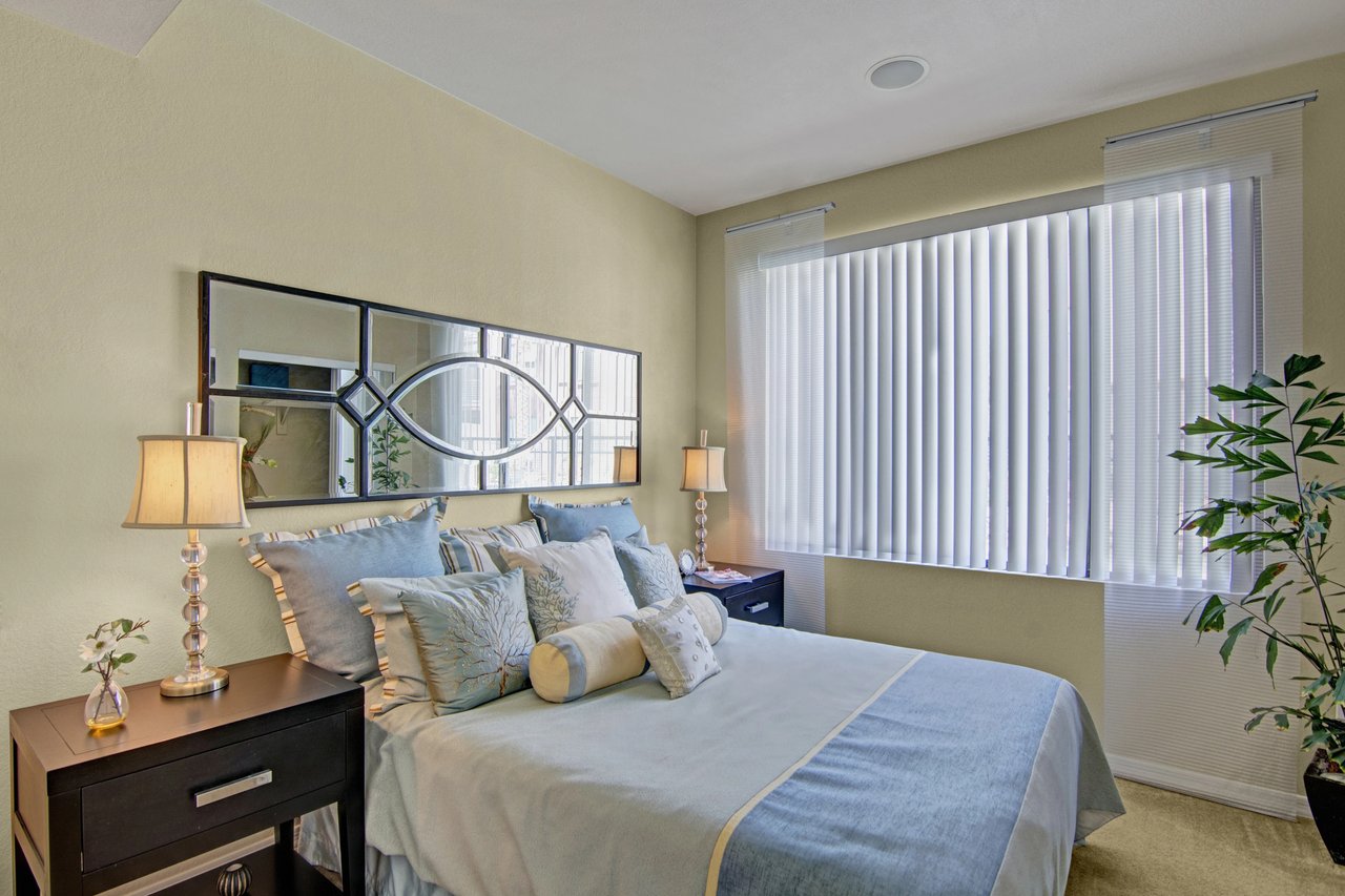 Bedroom with a king-size bed, nightstands, and a large mirror.