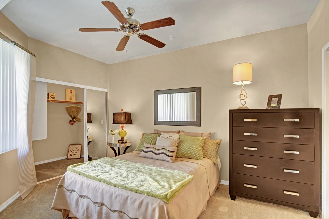 Bedroom with a queen-size bed, dresser, and closet.