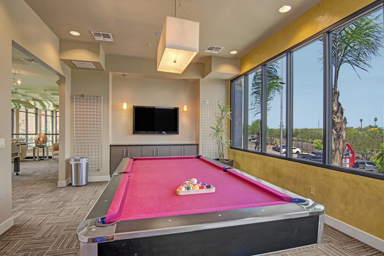 Billiards room with a pink felt pool table and a television.