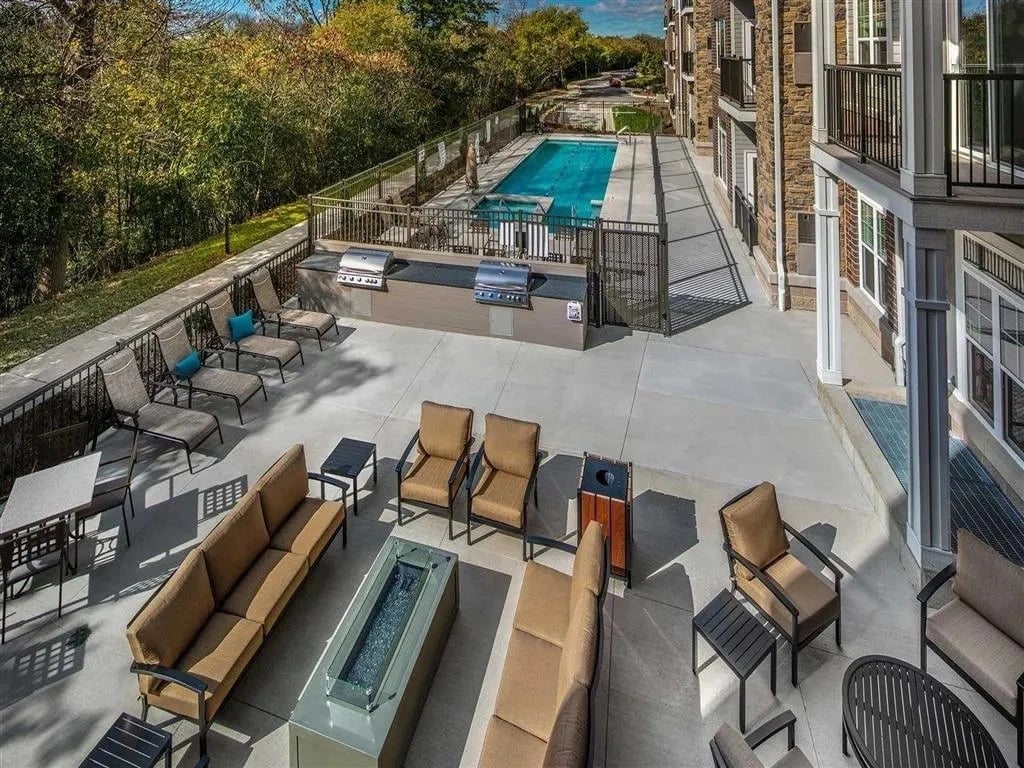 Outdoor lounge area with pool and grills