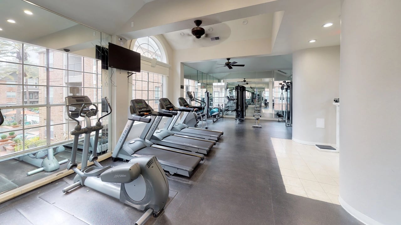 Fitness center with treadmills, ellipticals, and weight machines.