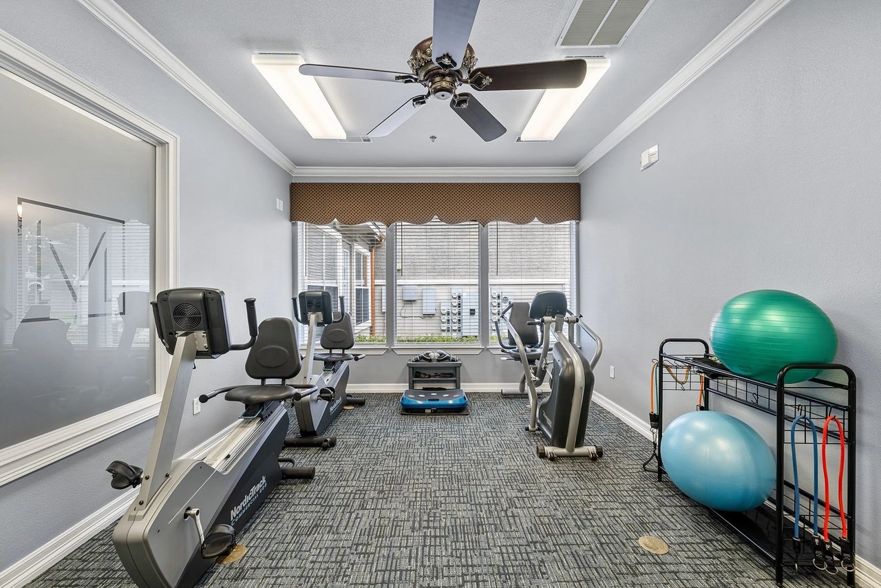 Fitness center with exercise bikes, elliptical machines, and exercise balls.