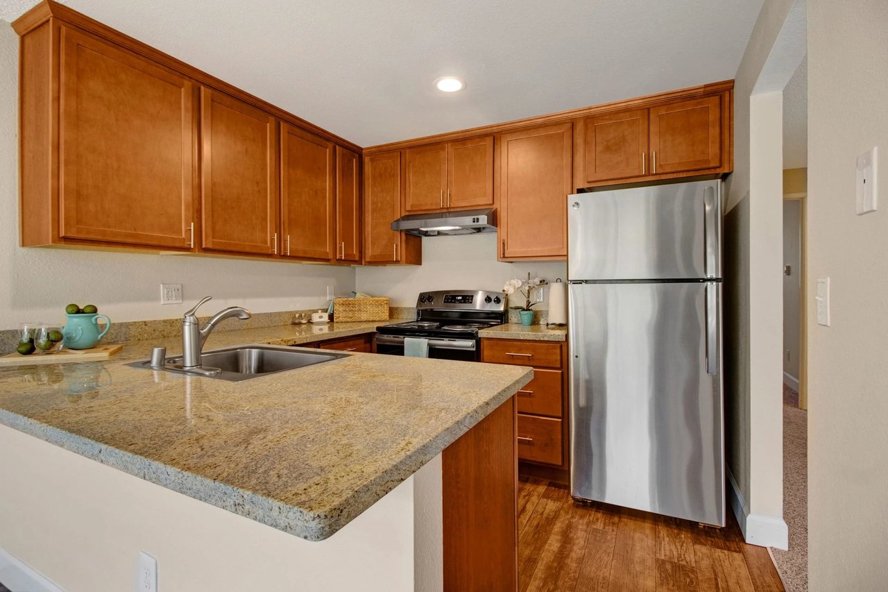 Kitchen with granite countertops, stainless steel appliances, and wooden cabinets.