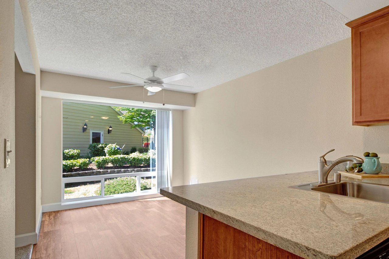 Kitchen counter with sink and view of living room and exterior.