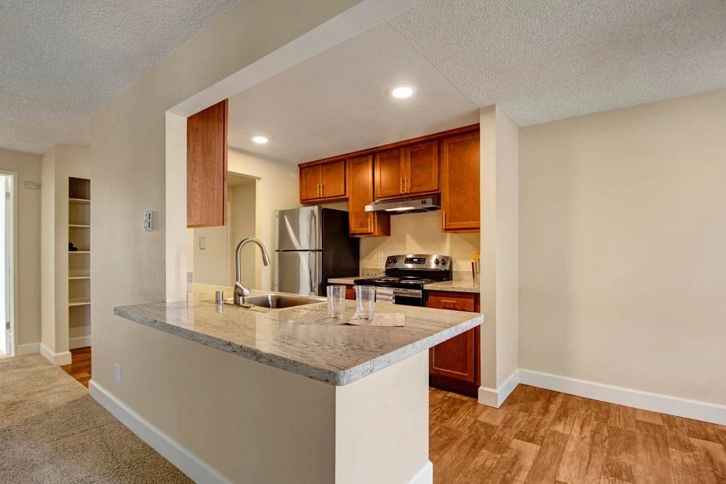 Kitchen with granite countertop and stainless steel appliances.