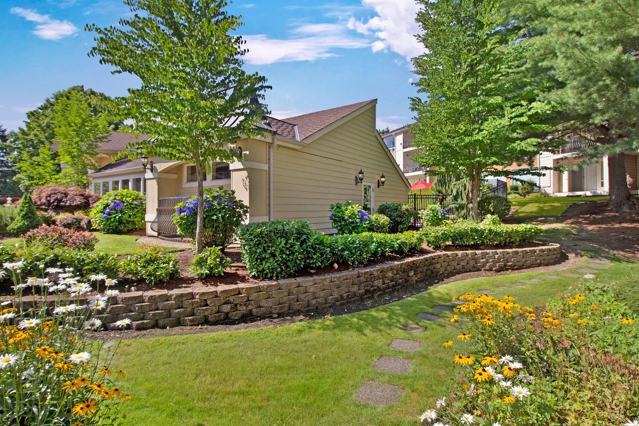 Manicured garden with stone pathway leading to a building.