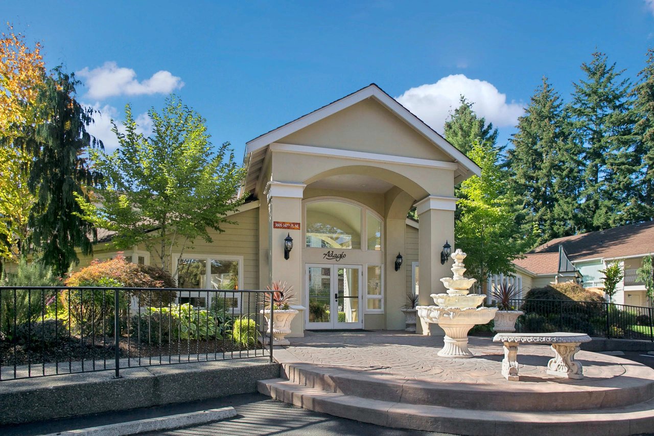 Adagio apartment building entrance with a fountain and landscaping.