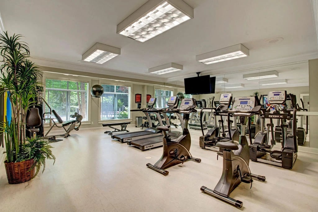 Fitness center with treadmills, elliptical machines, stationary bikes, and weight machines.