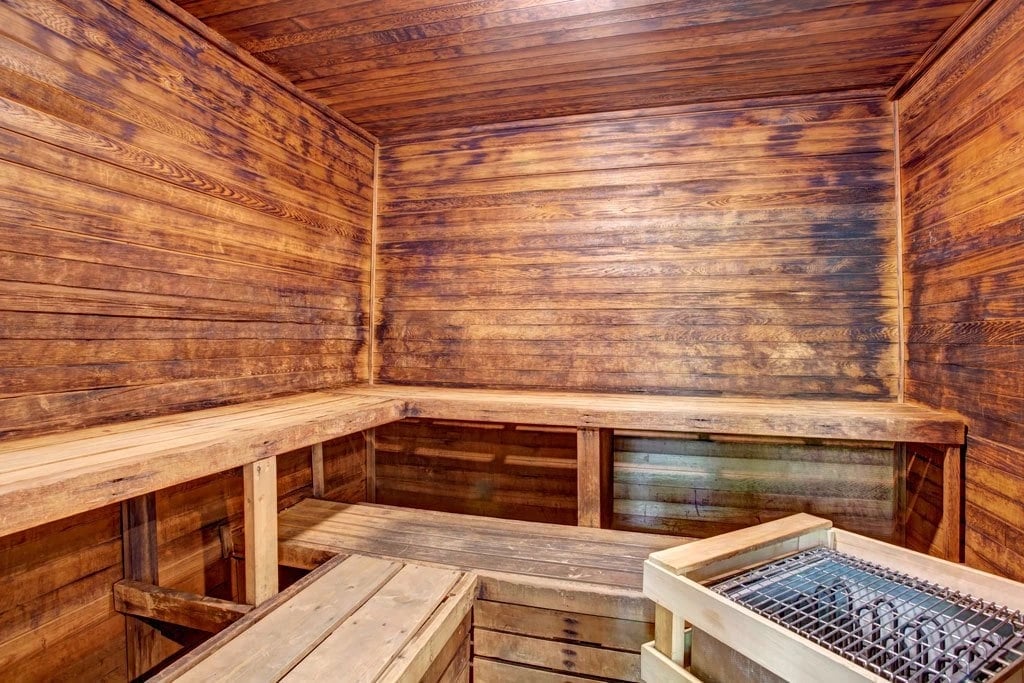 Interior of a wooden sauna with benches and a heater.