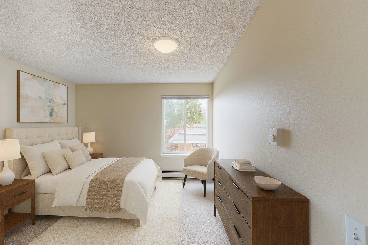 Bedroom with a queen-size bed, nightstand, dresser, and accent chair.