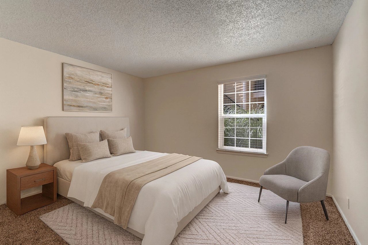 Bedroom with a queen-size bed, nightstand, chair, and window.