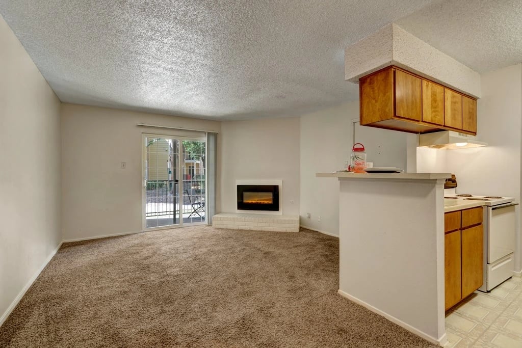 Living room with fireplace and adjoining kitchen