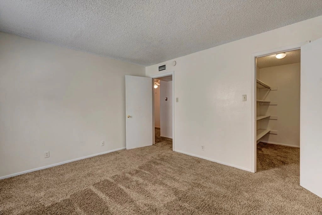 Bedroom with closet and doorway to another room