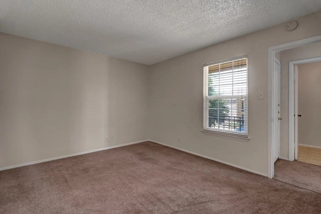 Empty bedroom with carpet and a window