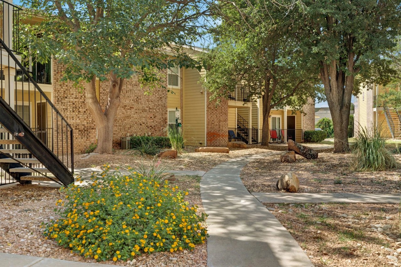 Exterior view of apartment buildings with walkways and landscaping.
