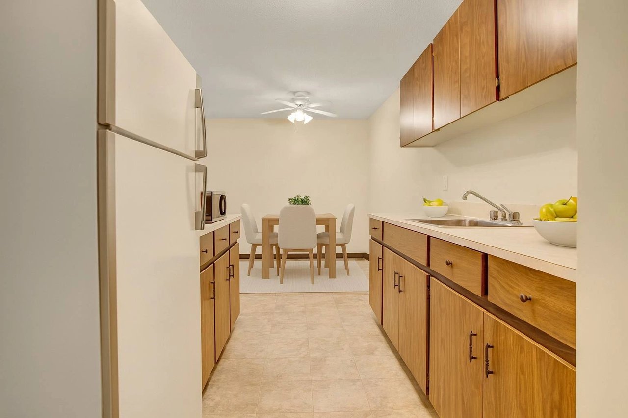 Kitchen and dining area with light wood cabinets and white countertops.