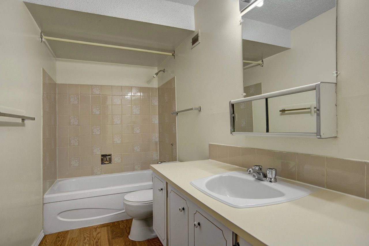 Bathroom with a bathtub, toilet, sink, and vanity.
