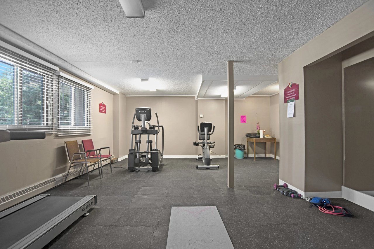 Gym with treadmills, elliptical, stationary bike, and weights