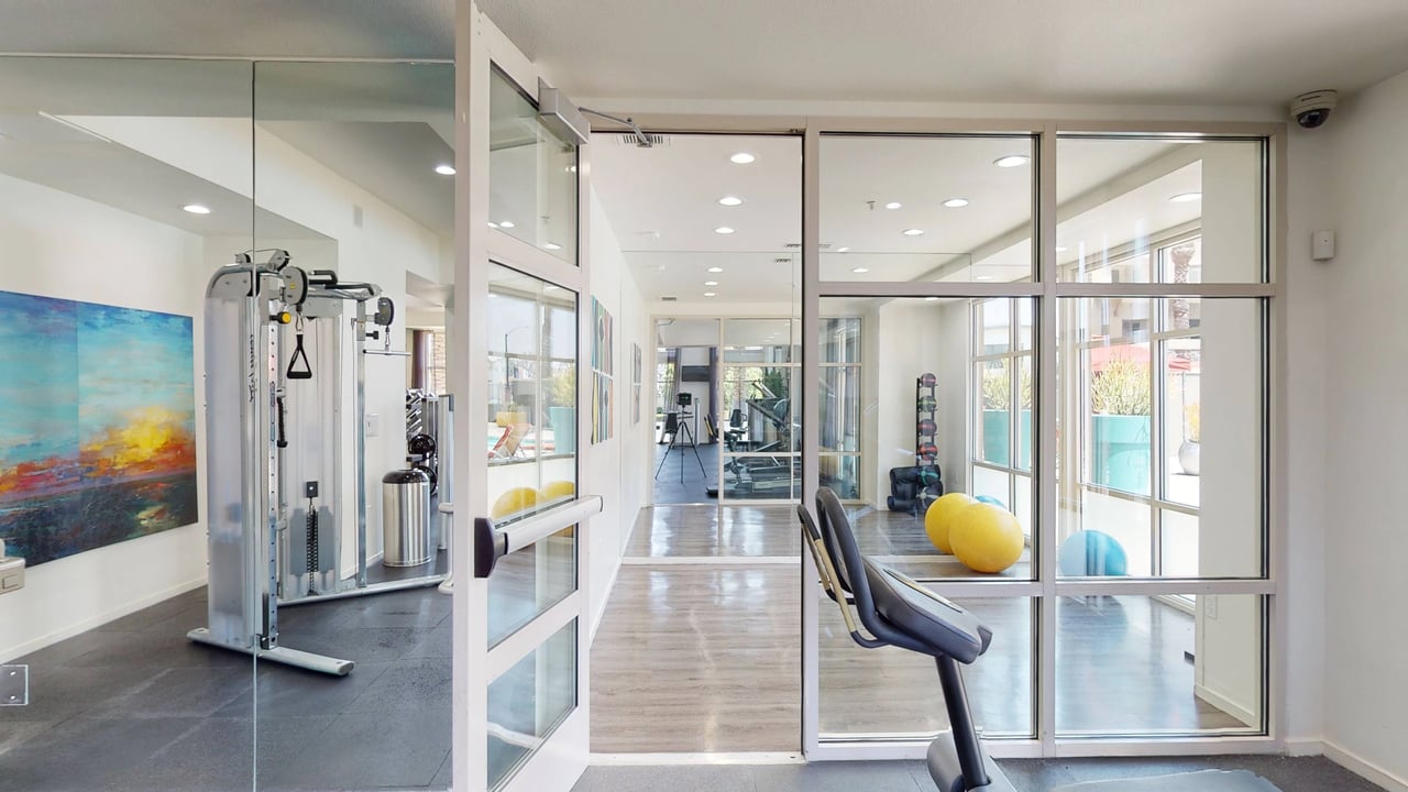 Gym with weight machines, treadmills, and yoga balls.