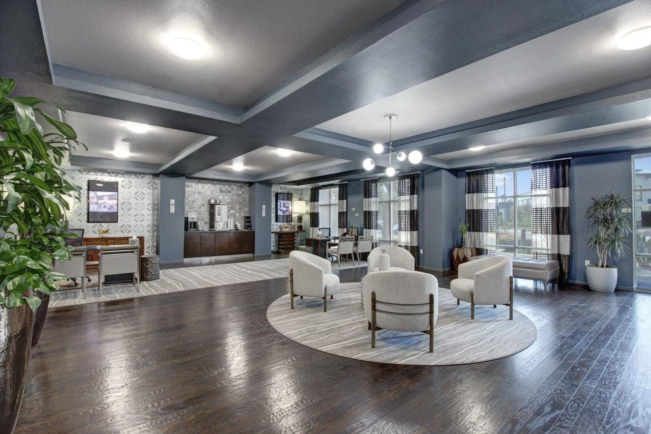 Modern lobby with a coffee station, seating area, and desk.