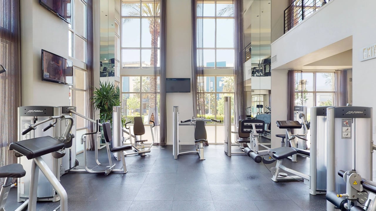 Gym with weight machines and large windows.