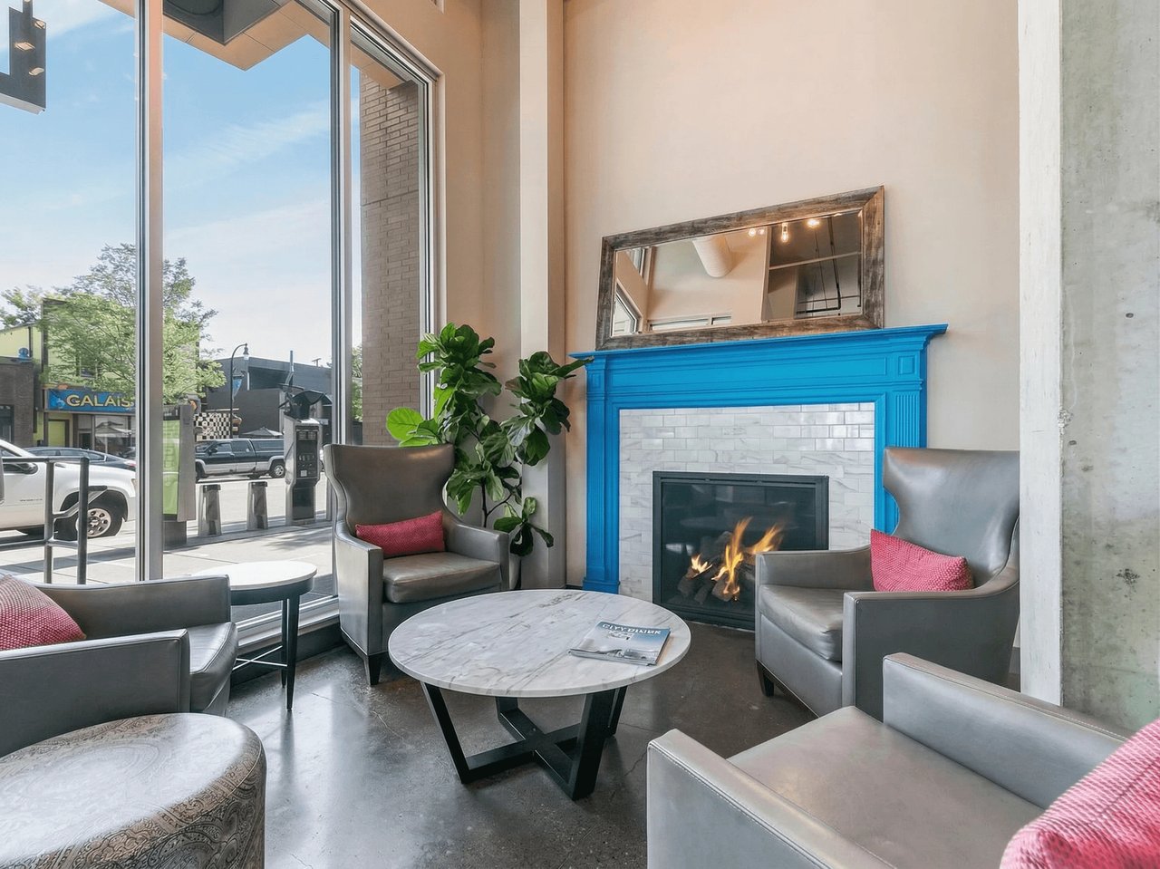 Lobby with fireplace, seating, and large windows