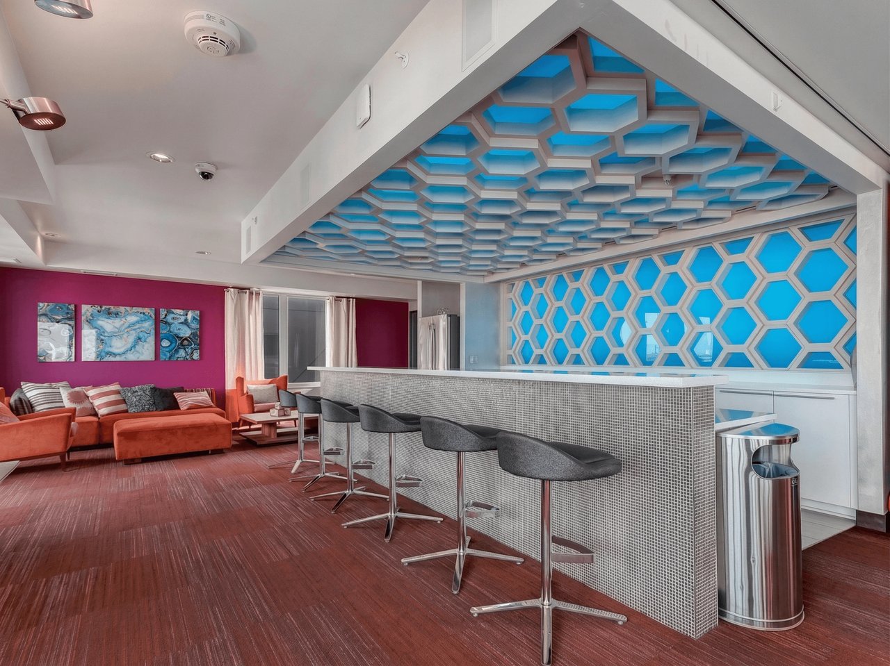 Bar area with contemporary design, honeycomb ceiling, and lounge seating.