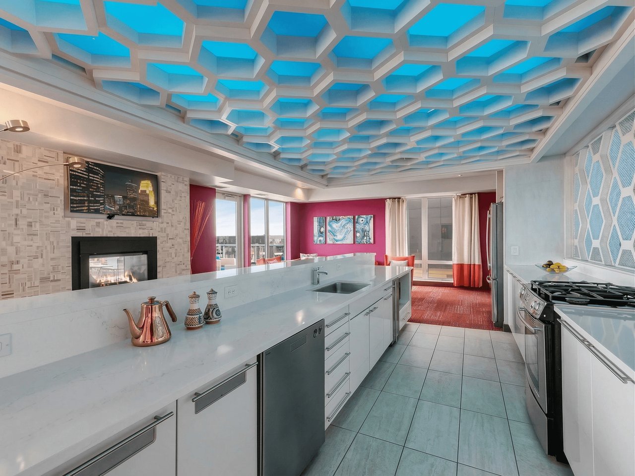 Modern kitchen with a large island, stainless steel appliances, and a unique hexagonal ceiling.