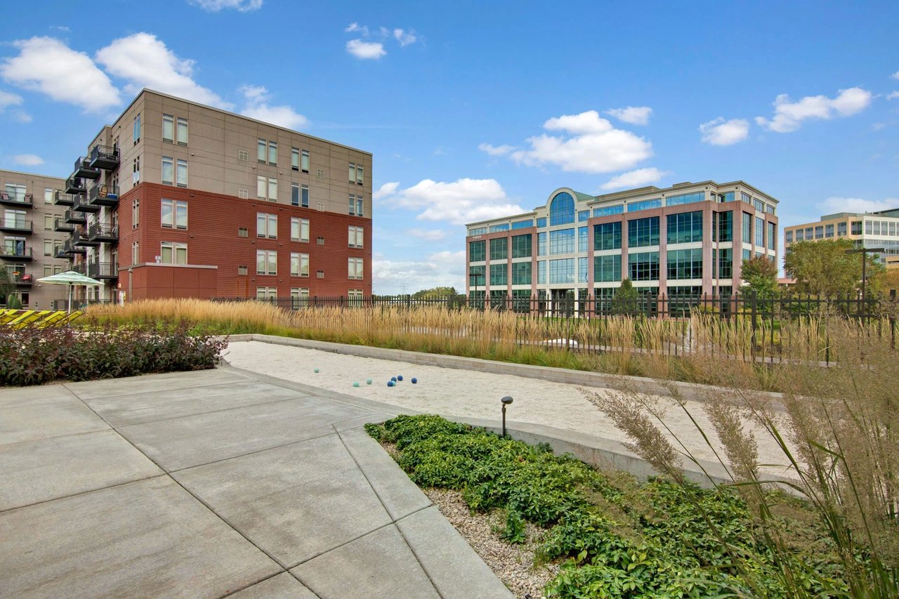 Exterior courtyard of a modern apartment complex with walkways and landscaped grounds.