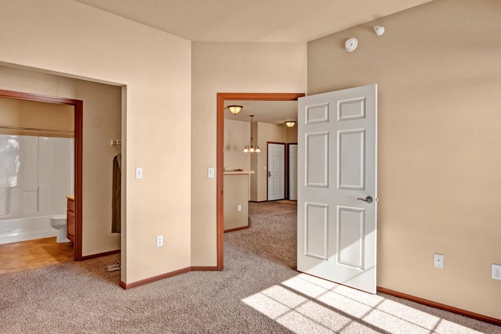 Interior view of an apartment, showing a living room, bathroom, and hallway.