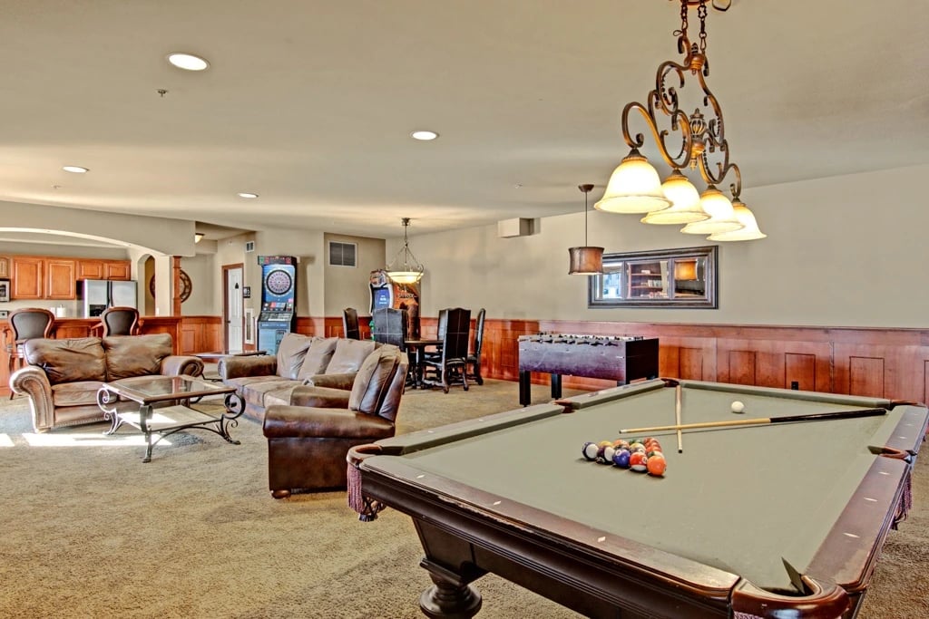 Community lounge with pool table, foosball, dartboard, seating, and bar area.