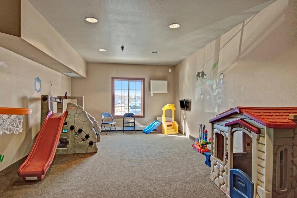Children's play area with slides, playhouse, and basketball hoop.