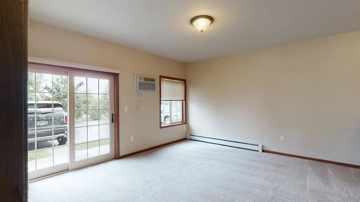 Living area with carpet and sliding glass doors