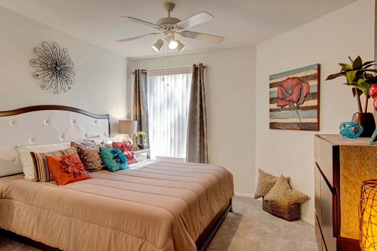 Spacious bedroom with a king-size bed, plush bedding, and decorative pillows.