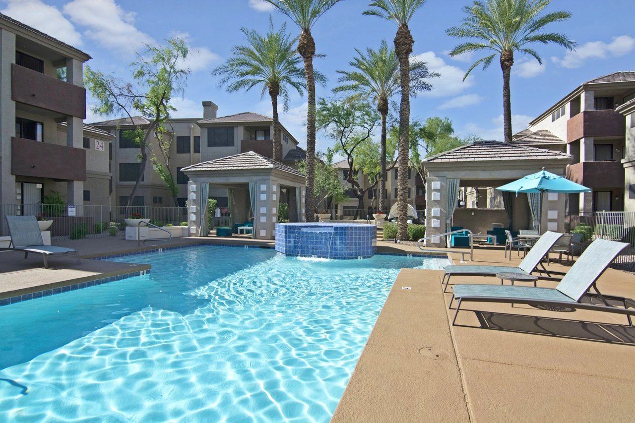 Resort-style swimming pool with lounge chairs and cabanas