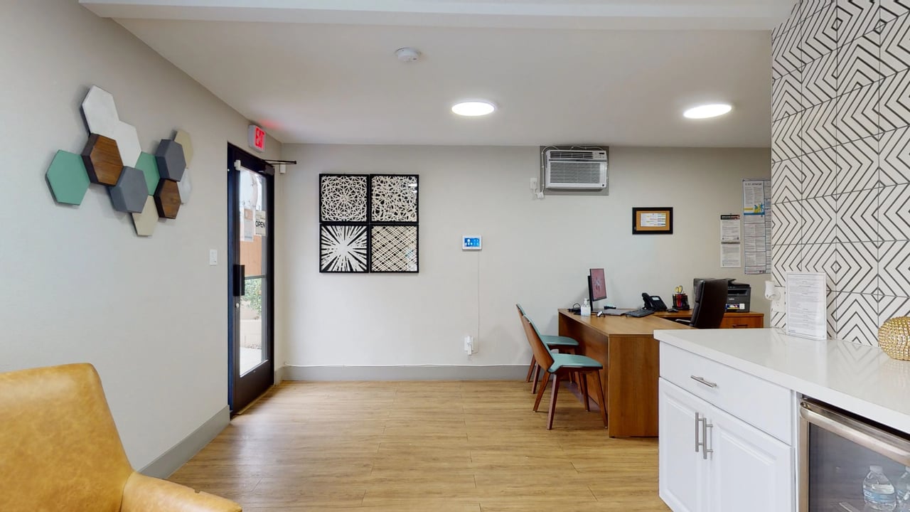 Apartment building lobby with reception desk, seating, and modern decor.