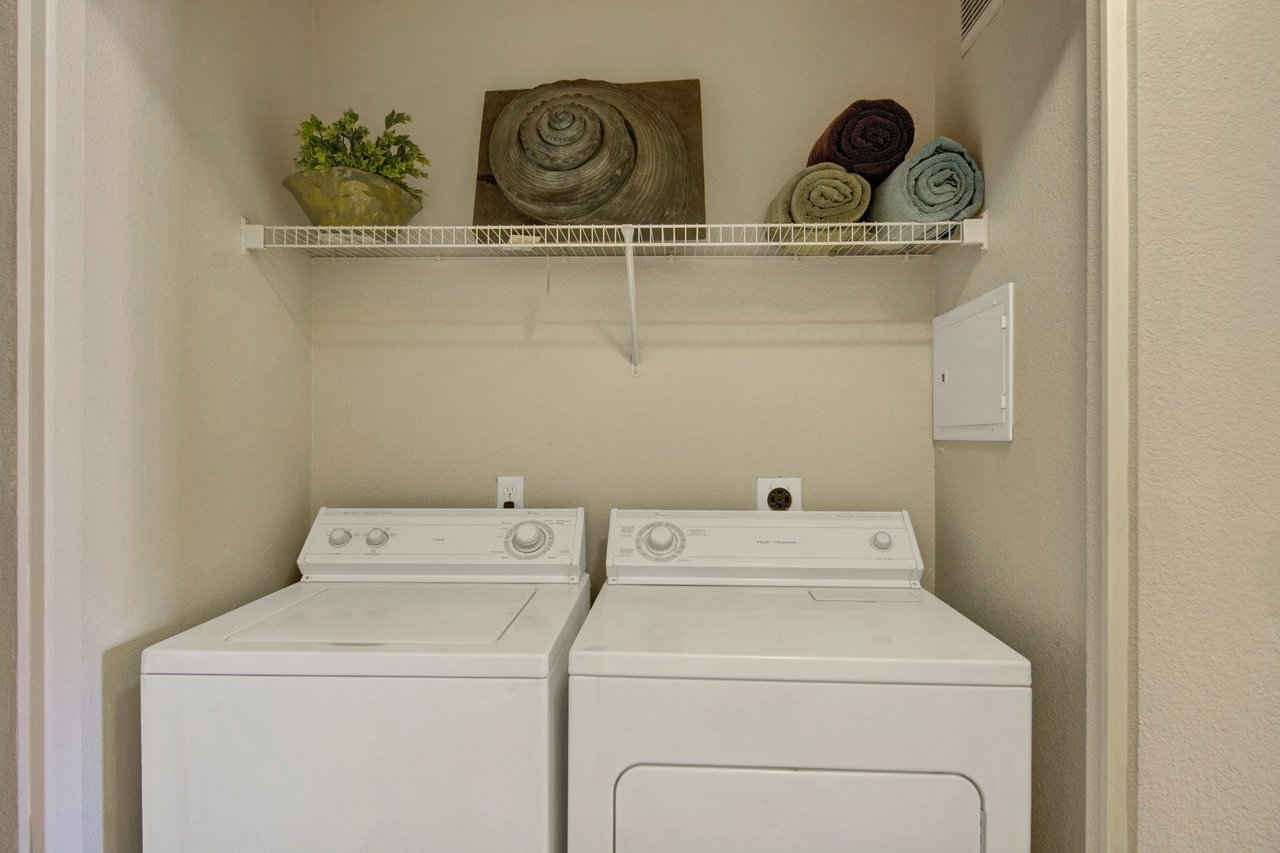 Stackable washer and dryer set inside an apartment closet.
