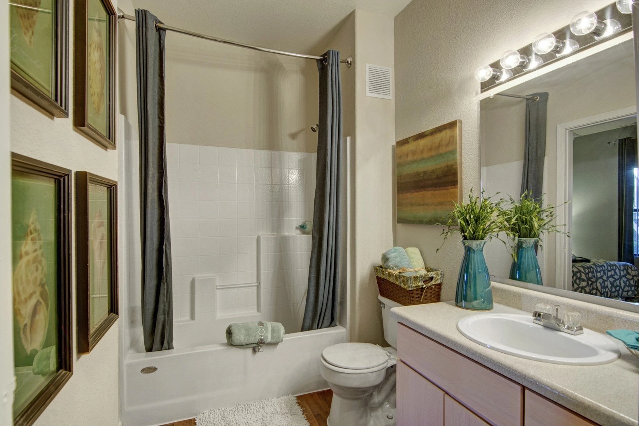 Bathroom with a bathtub, shower, toilet, and vanity with a sink.