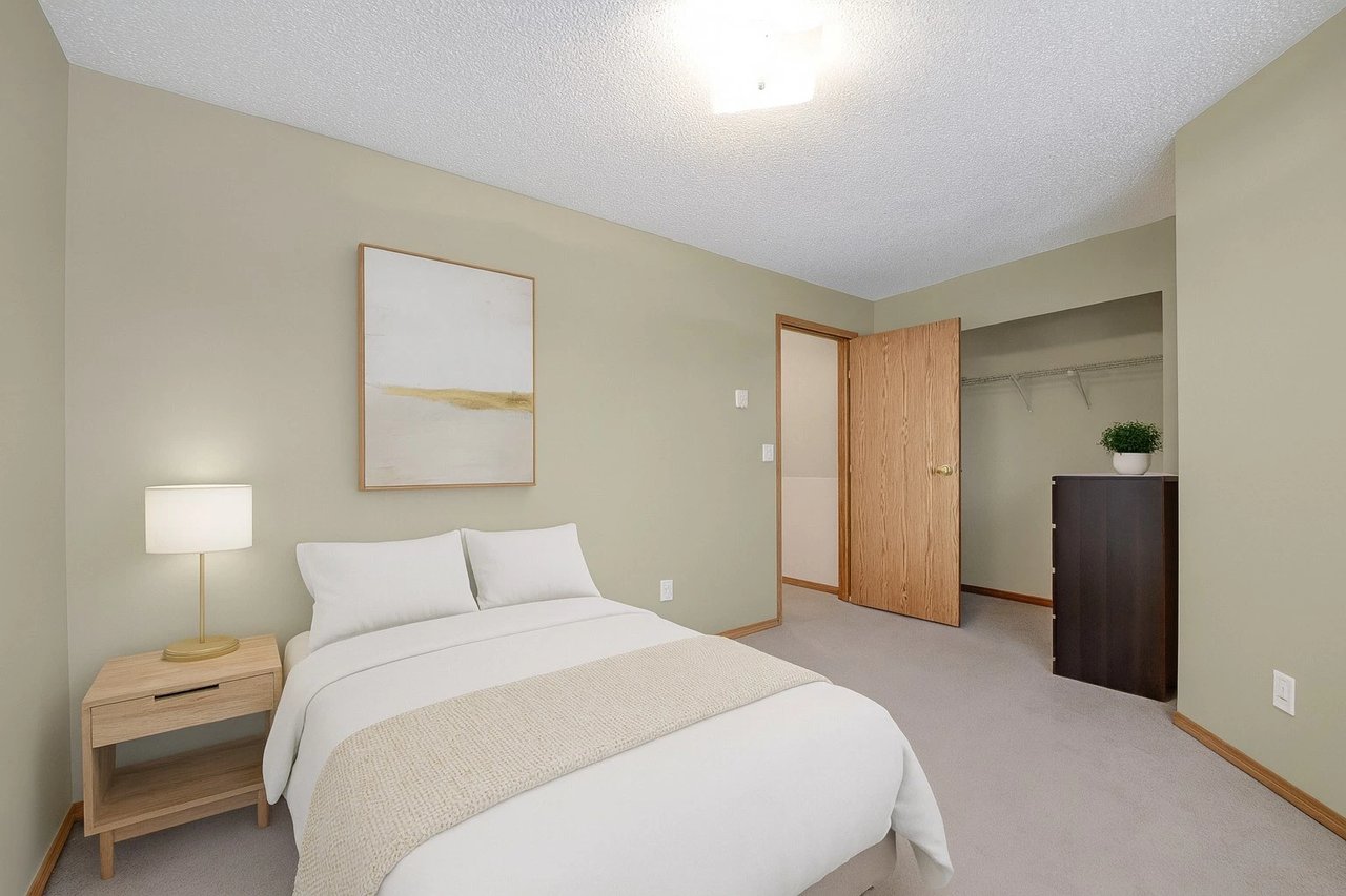 Bedroom with a queen-sized bed, nightstand, and closet.