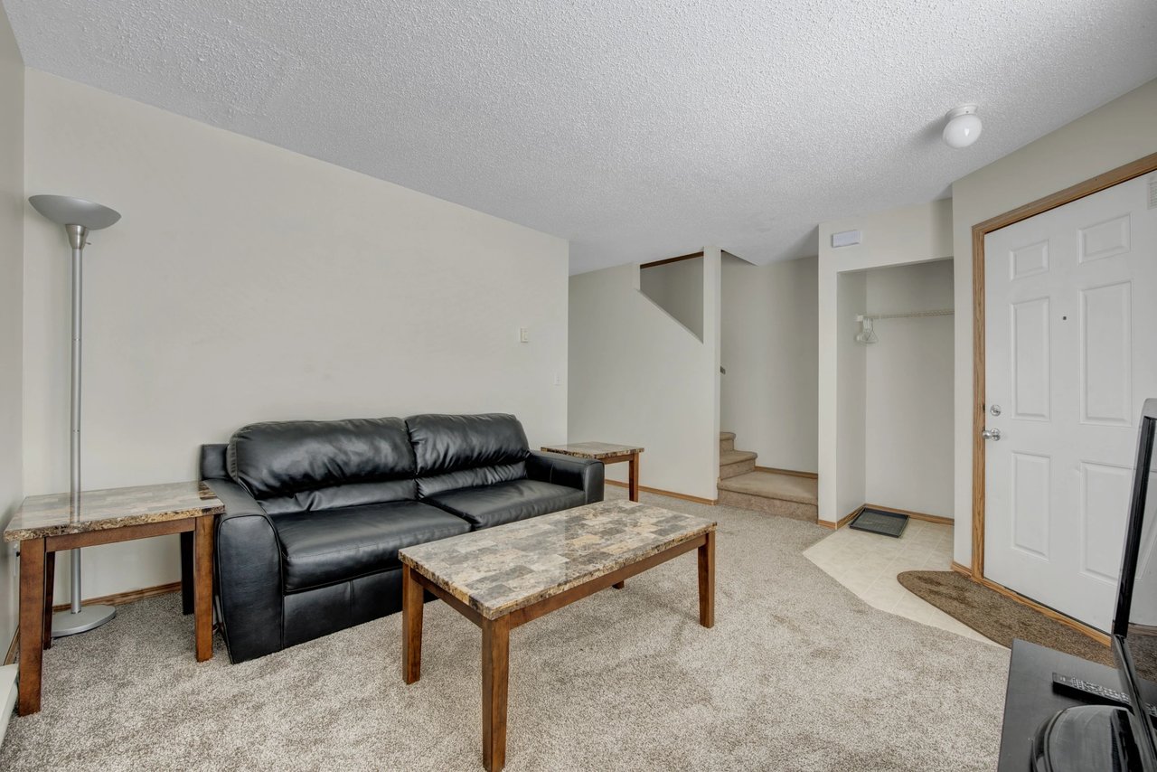 Living room with a black leather sofa, coffee table, and end tables.