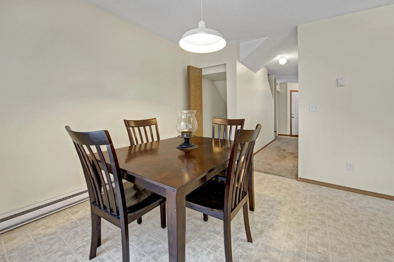Dining area with dark wood table and chairs.
