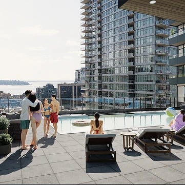 People relaxing by the rooftop pool and lounge area with city views.