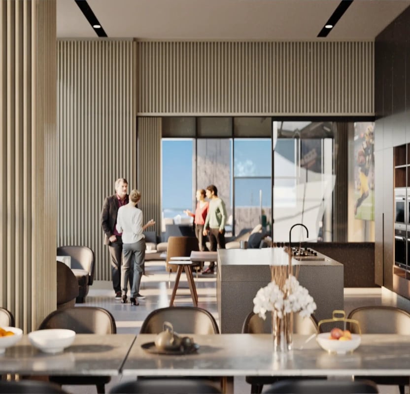 People socializing in a modern apartment building lobby with a kitchen island and dining table in the foreground.