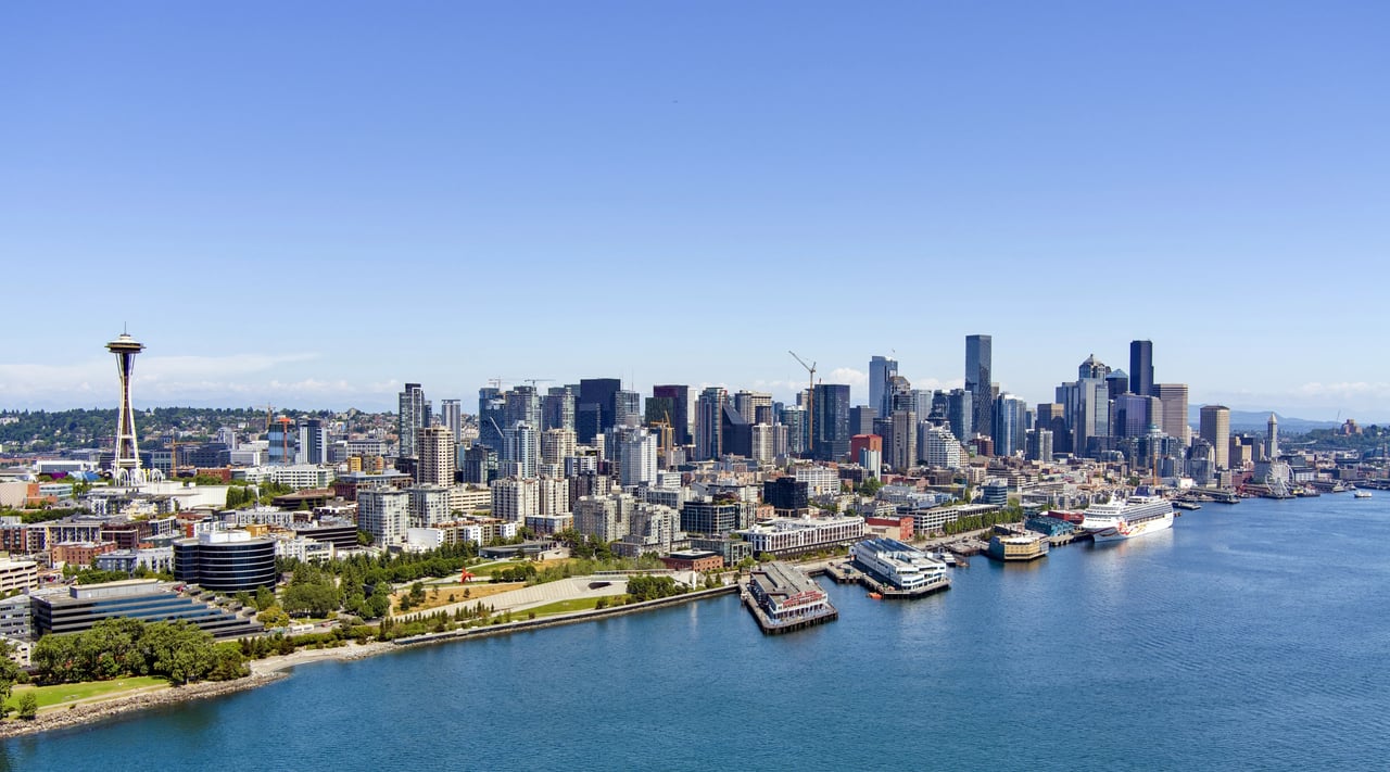 Seattle skyline with Space Needle and waterfront buildings.
