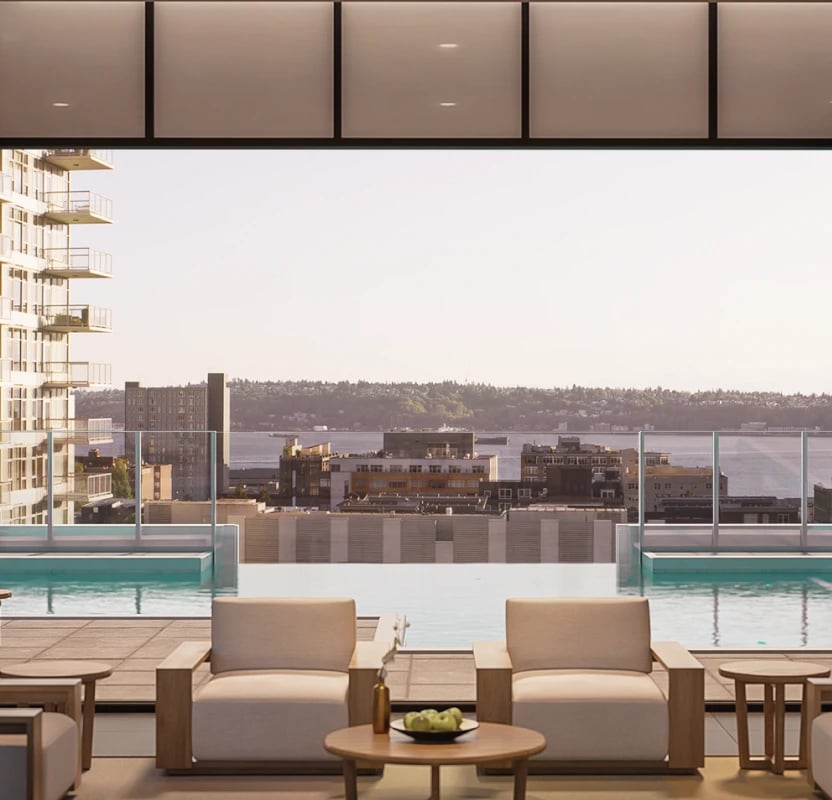 Rooftop infinity pool with lounge chairs overlooking a city skyline and waterfront.