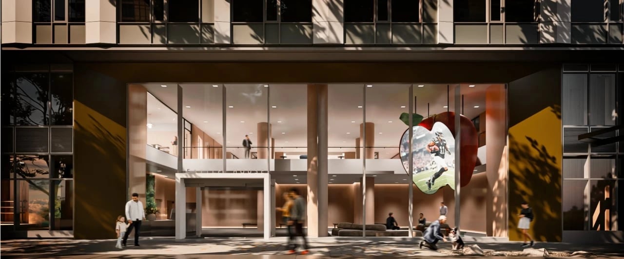 Entrance to a modern apartment building with a large apple-shaped screen displaying a football player.
