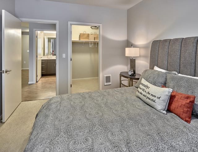 View of a bedroom with a king-size bed, nightstand, and closet.