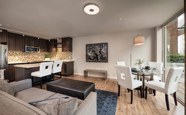 Modern apartment living and dining area with a kitchen island and seating.
