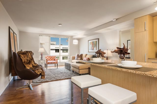 Living room with large window and modern furniture.